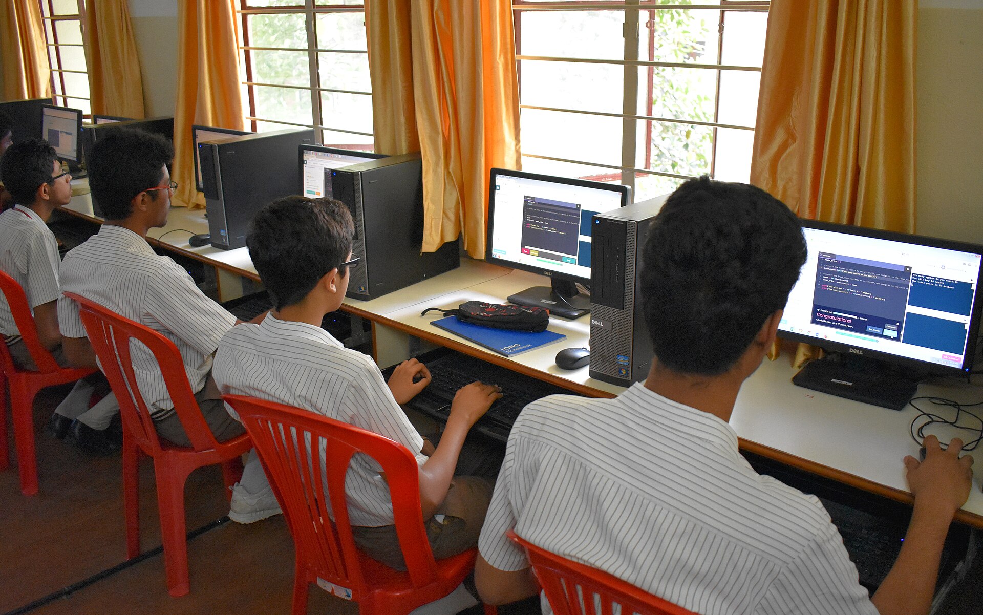 Students in school uniform working at computers in a school computer lab in Bangalore, India